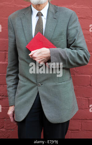 ältere Mann mit einer roten Backsteinmauer Stockfoto