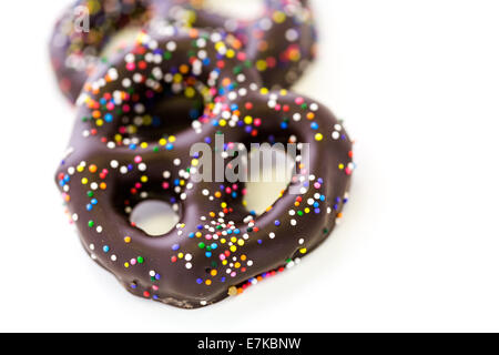 Gourmet-Schokolade überdachten Brezel mit Schokolade bedeckt Brezel mit bunten Streuseln auf weißem Hintergrund. Stockfoto