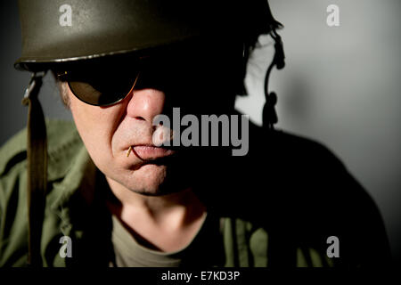 Porträt einer Vietnam-Krieg Periode, die amerikanischen Soldaten, das Tragen von Sonnenbrillen mit Hälfte seines Gesichts teilweise durch Schatten bedeckt hautnah. Stockfoto