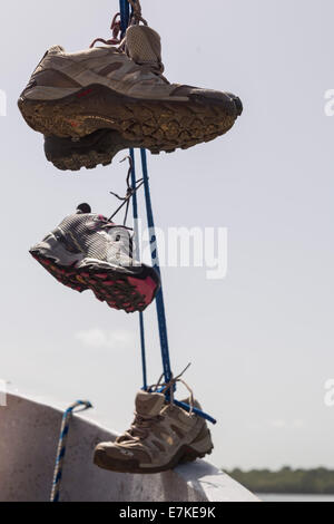 Drei Schuhe hängen von der Linie eines Bootes Stockfoto