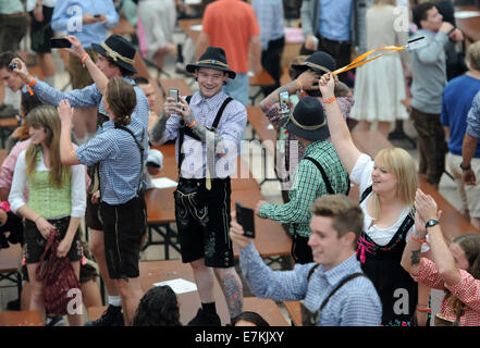 München, Deutschland. 20. Sep, 2014. Menschen besuchen die Eröffnung des Oktoberfest in München, Deutschland, 20. September 2014. Eine 1-Liter-Stein bayerisches Bier kostet bis 10,10 Euro (13,70 US-Dollar) in riesigen Zelten, wo der Welt Nachtschwärmer in der Größenordnung von Oompah Musik trinken. Touristischen Beamte sagten, die durchschnittliche Bier Preis knapp drei Prozent im Vergleich zum Jahr 2013 gestiegen war. 181. Oktoberfest dauert bis zum 5. Oktober 2014. Foto: ANDREAS GEBERT/Dpa/Alamy Live-Nachrichten Stockfoto