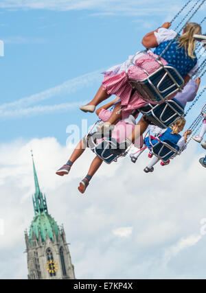 München, Deutschland. 20. Sep, 2014. Menschen in einem fliegenden schwingen vor der St.-Pauls-Kirche auf dem Oktoberfest in München, Deutschland, 20. September 2014. 181. Oktoberfest dauert bis zum 5. Oktober 2014. Foto: Marc Müller/Dpa/Alamy Live News Stockfoto