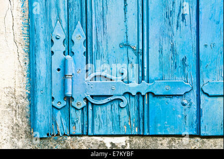 Dekorative Scharnier auf einen alten blauen Holzfenster-Verschluss Stockfoto