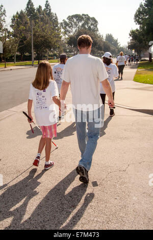 Ein blinde Teenager bekommt eine helfende Hand von ihrem Vater während einer Wohltätigkeitsorganisation, die Mittelbeschaffung Spaziergang in Tustin, CA. Hinweis weißen Zuckerrohr. Stockfoto