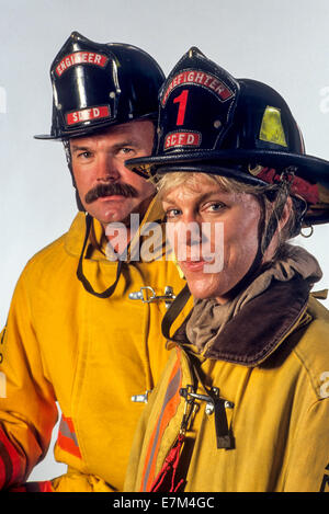 Männliche und weibliche Feuerwehr Modell schützende Jacken und Helme in San Diego, Kalifornien. Stockfoto