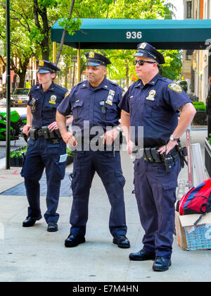 Eine weibliche und zwei männliche Polizisten stehen auf einem Bürgersteig auf der Upper East Side in Manhattan, New York City. Stockfoto