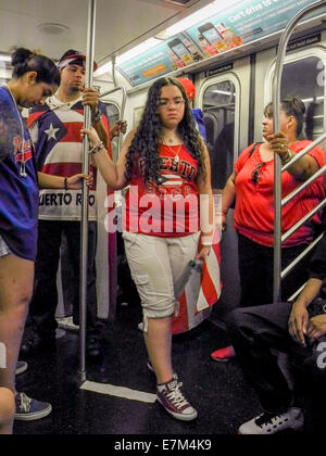 Tragen patriotische Kleidung mit der Puerto-Ricanischen Flagge, Hispanic Passagiere in einer New Yorker u-Bahn-Wagen, Reisen einige davon fettleibig, nach Puerto Rican Day Parade auf der Fifth Avenue. Stockfoto