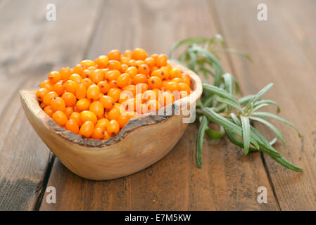 Sanddorn Beeren in Schüssel auf einem hölzernen Hintergrund Stockfoto
