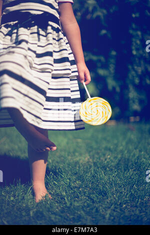 Kleines Mädchen mit einem Lutscher in der Hand. Closeup. Stockfoto