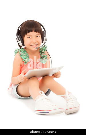 lächelnd Schüler Mädchen sitzen und halten ein Tablet mit Kopfhörer. isoliert auf weißem Hintergrund Stockfoto