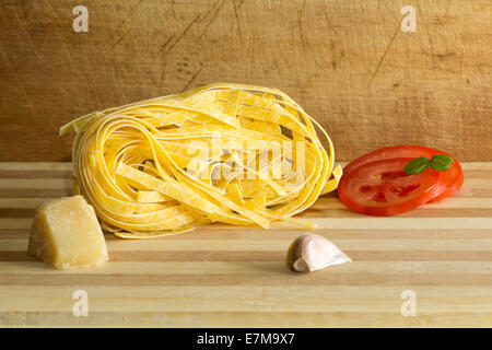 Italienische Pasta mit Zutaten auf einem Holzbrett Stockfoto