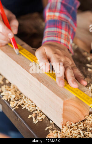 Des Tischlers Hand Kennzeichnung auf Holz In Werkstatt Stockfoto