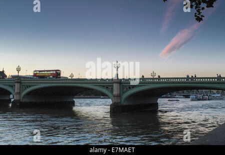 Eine rote London Bus Geschwindigkeiten über die Westminster Bridge in den Sommern twilight Stockfoto