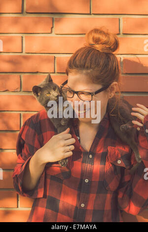 Glücklich niedlich Hipster Mädchen albern und spielen mit ihrer Russisch Blau Katze Stockfoto