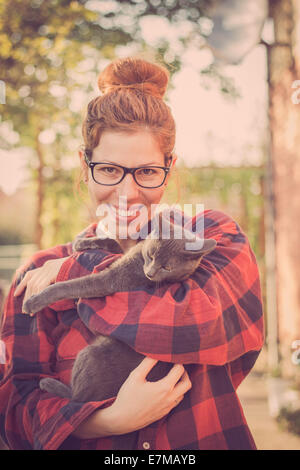 Glücklich niedlich Hipster Mädchen albern und spielen mit ihrer Russisch Blau Katze Stockfoto