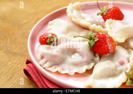 Knödel mit Beeren und Sahne-Sauce, serviert mit frischen Erdbeeren Stockfoto