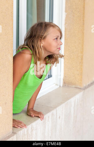 Blonde kaukasische Mädchen im Fenster "" Outdoor-Porträt Stockfoto