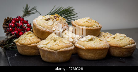 Mince Pies präsentiert auf einer Schiefertafel Platte mit Winter Beeren Stockfoto
