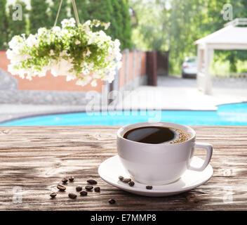 Tasse heißen Kaffee auf einem alten Holztisch in der Café-Terrasse. Stockfoto