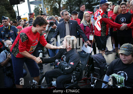 Ottawa, Kanada. 21. Sep, 2014. Führer der Liberalen Partei von Kanada Justin Trudeau (Front L) regt Greg Jamesn am 2014 Kanada Armee Durchlauf in Ottawa, Kanada, am 21. September 2014. Verletzte Soldaten und behinderten Sportlern gehörten zu 25.000 Läufer auf der jährlichen Veranstaltung, die hilft, Geld für Soldaten und deren Angehörige. Bildnachweis: Cole Burston/Xinhua/Alamy Live-Nachrichten Stockfoto