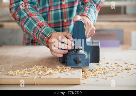 Tischler arbeiten mit elektrischen Hobel auf Holz Stockfoto