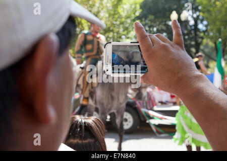 Mann für Videoaufnahmen der Veranstaltung bei einem Outdoor-Festival mit Smartphone - USA Stockfoto