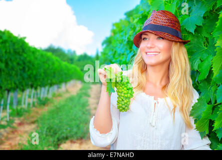 Glücklich lächelnd Bauernmädchen arbeiten im Weinberg, Kommissionierung süße reife Bündel von Traube, Herbst Erntezeit, Weinbau Konzept Stockfoto