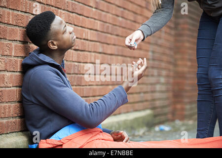 Teenager-Jungen schlafen auf der Straße Geld gegeben Stockfoto