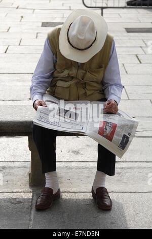 Älterer Mann, der Zeitung liest, sitzt auf einer Bank in Turin, Italien Stockfoto