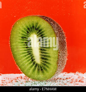 die Hälfte der Kiwi mit Bläschen im Sodawasser Stockfoto