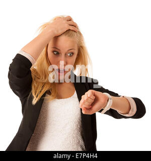 Junge blonde Frau schaut auf ihre Uhr, wenn sie spät über weißen Hintergrund isoliert wird, ist Stockfoto