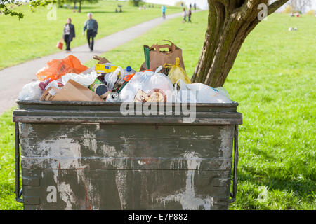 Große Mülltonne voller Müll in einem Park in London, England, Großbritannien Stockfoto