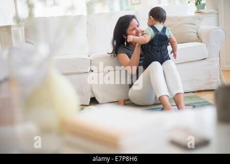 Mutter mit ihrem Sohn (6-11 Monate) im Wohnzimmer spielen Stockfoto