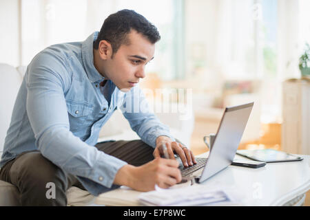 Mann arbeitet im Wohnzimmer Stockfoto