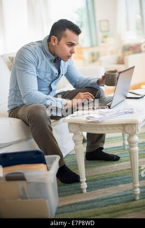 Mann arbeitet im Wohnzimmer Stockfoto