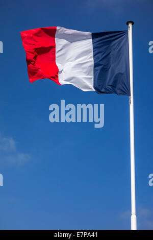 Französische Nationalflagge Frankreichs am Fahnenmast im Wind gegen blauen Himmel Stockfoto