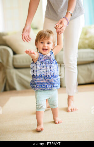 Mutter Mitarbeitende Tochter (18-23 Monate) bei ihren ersten Schritten Stockfoto