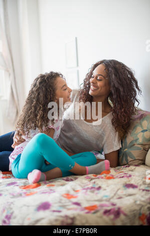 Mutter und Tochter (8-9) sitzt auf Bett Stockfoto