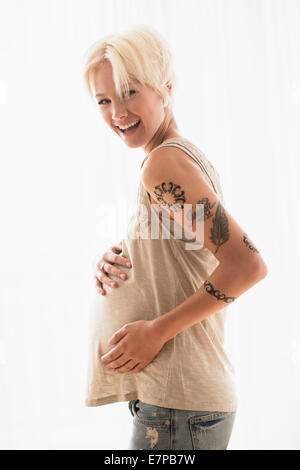 Schwangere Frau mit Händen auf Magen Stockfoto