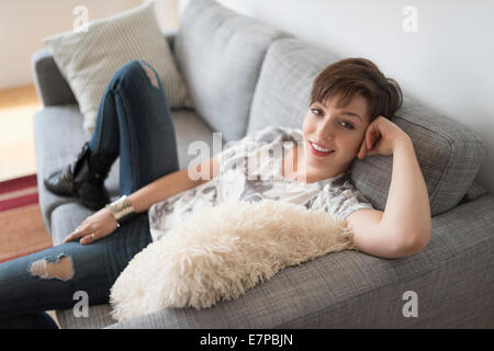 Porträt der lächelnde Frau sitzend auf sofa Stockfoto