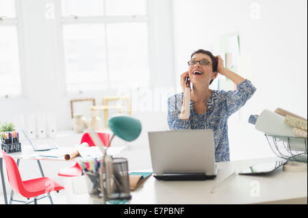 Senior Business-Frau mit Handy im Büro Stockfoto