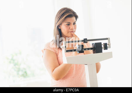 Frau stehend im Maßstab Stockfoto