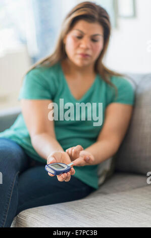 Frau sitzt auf dem Sofa mit Handy Stockfoto