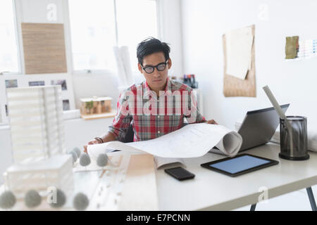 Architekt, Blick auf Blaupausen in Büro Stockfoto