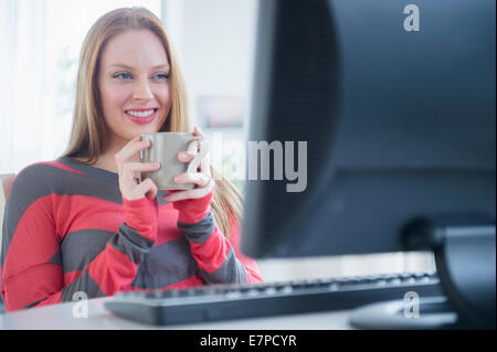 Junge Frau vor computer Stockfoto