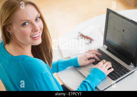 Lächelnde junge Frau mit Laptop Stockfoto