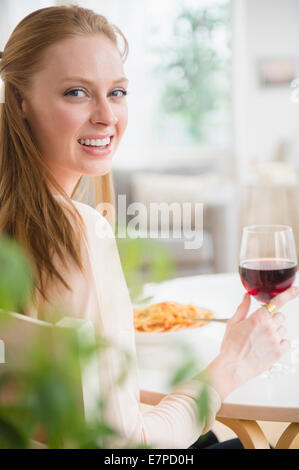 Frau, die Mahlzeit mit Rotwein Stockfoto