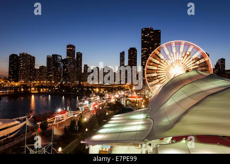 USA, Illinois, Chicago, beleuchtete Riesenrad mit Wolkenkratzern im Hintergrund Stockfoto