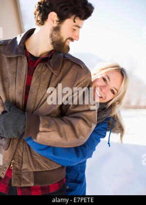 Junge Frau umarmen Mann im winter Stockfoto