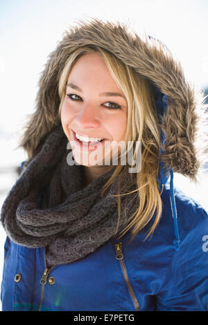 Porträt der lächelnde junge Frau im Winter Mantel Kapuze Stockfoto